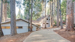 A residential area with two houses, a gravel driveway, and tall trees. - Pollock Pines Cabin: Game Room w/ A/C & Heat! (Pollock Pines)