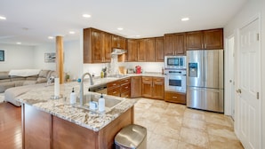 A modern kitchen with wooden cabinets, granite countertops, stainless steel appliances, and a built-in island with a sink. - Pollock Pines Cabin: Game Room w/ A/C & Heat! (Pollock Pines)