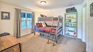 A bunk bed with a ladder, a bookshelf, a desk, and a window with curtains. - Dreamy Riverside Cabin With Fireplace & Grill (Concrete)