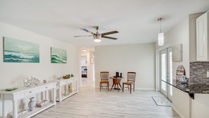 A spacious kitchen with a dining area, white cabinetry, and a ceiling fan. - 'space Coast' Getaway w/ Outdoor Pool & Spa! (Palm Bay)