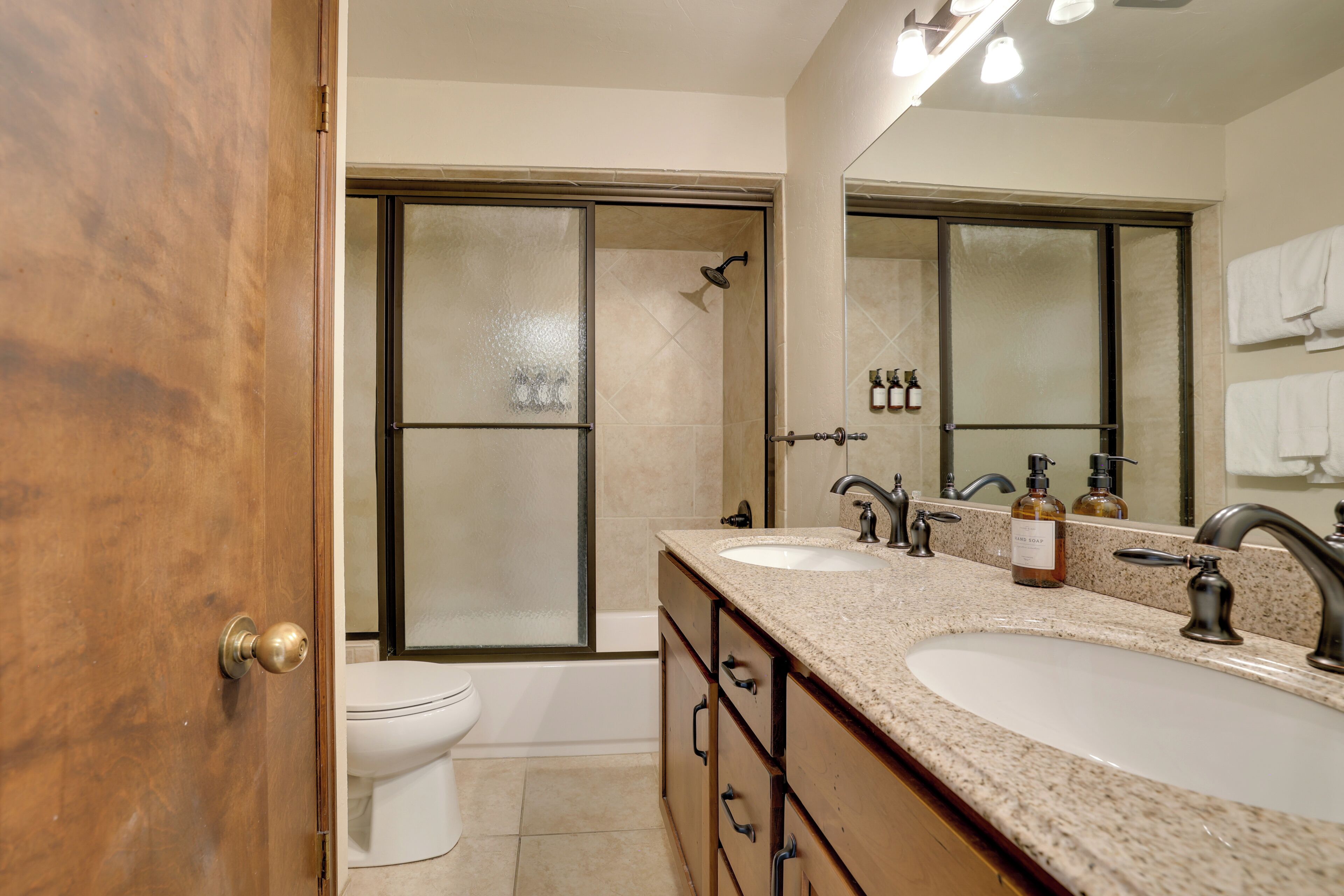 Une salle de bain avec deux lavabos, une douche et des toilettes.