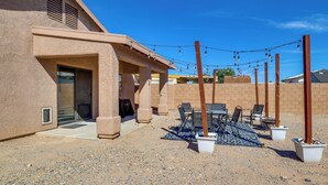 A covered outdoor patio with a table and chairs, a string of lights, and planters. - Inviting Bullhead City Gem: 3 Mi to Colorado River (Bullhead City)