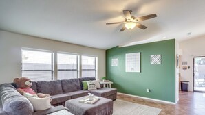 A living room with a grey sectional sofa, a small white table, a grey ottoman, and a ceiling fan. - Inviting Bullhead City Gem: 3 Mi to Colorado River (Bullhead City)