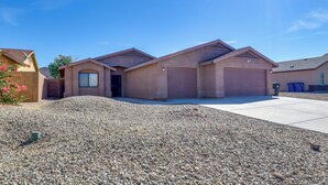 A two-story house with a garage, a driveway, and a gravel front yard. - Inviting Bullhead City Gem: 3 Mi to Colorado River (Bullhead City)
