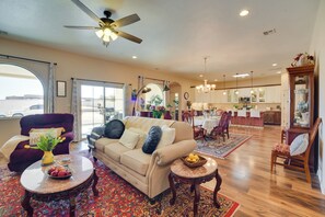 A spacious living room with a sofa, coffee table, and a dining area with chairs and a table.