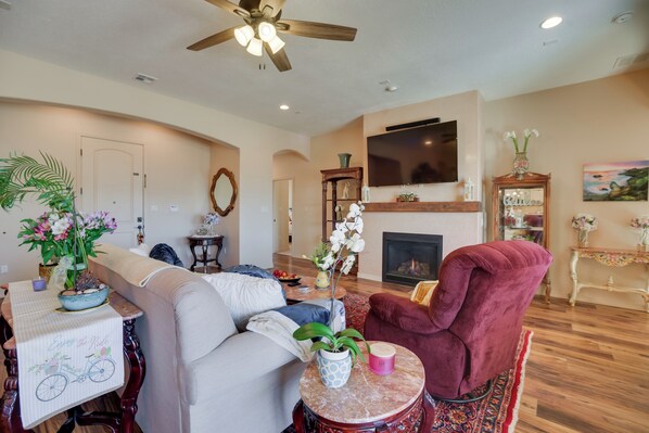 A living room with a sofa, armchair, coffee table, and fireplace.