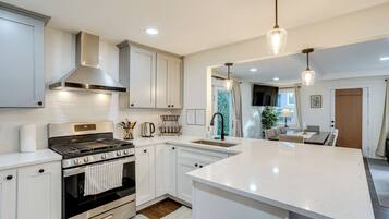 Una cocina moderna con armarios blancos, electrodomésticos de acero inoxidable y una isla grande.
