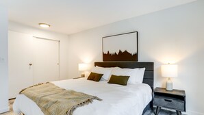 A neatly made bed with a patterned throw, two bedside tables with lamps, and a framed picture on the wall. - Beautiful Kenmore Retreat Near Marina & Beach! (Kenmore)