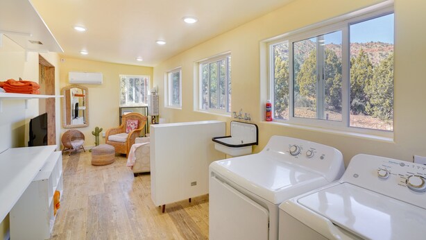 A laundry room with two washing machines, a sink, and a window with a view of trees. - Kanab Studio Escape: Stargaze, Hike, Relax! (Kanab)