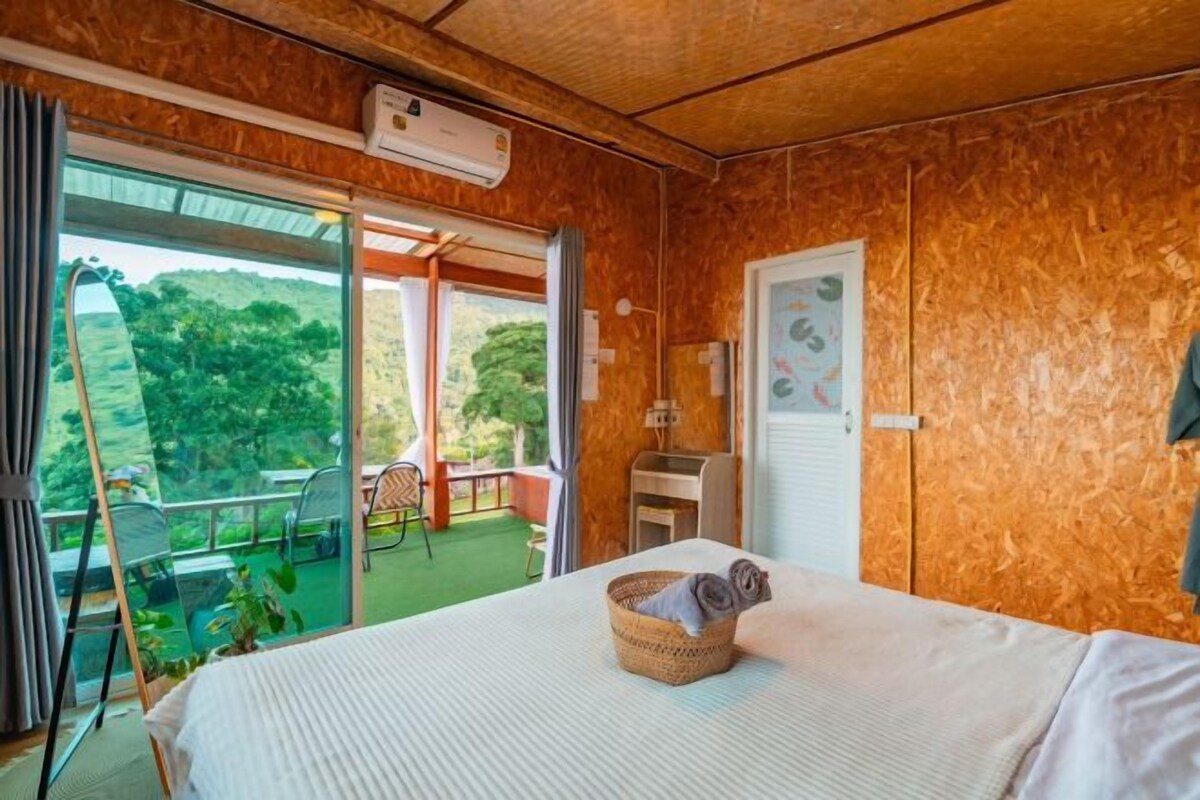 A bedroom with a bed, a window, and a view of the outdoors.