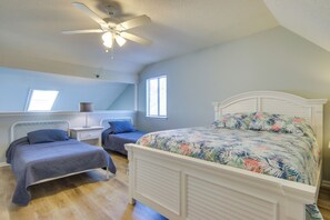 A bedroom with a large bed, two smaller beds, a ceiling fan, and a window. - 1/2 Mi to Maryland Beach: Family Condo w/ Balcony (Ocean City)