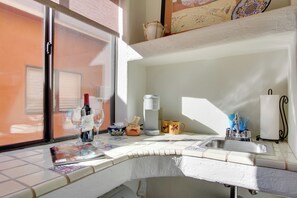 A kitchen with a window, a sink, and various kitchen items.