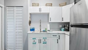 A compact kitchen with white cabinets, a stainless steel refrigerator, and a small countertop. - Clearwater Vacation Rental w/ Furnished Patio! (Clearwater)