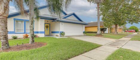 A single-story house with a front yard, a garage, and a small garden area.