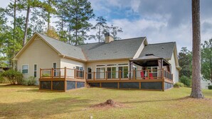 A two-story house with a deck, large windows, and a chimney. - Mccormick Home: Monticello Golf Club Getaway! (McCormick)