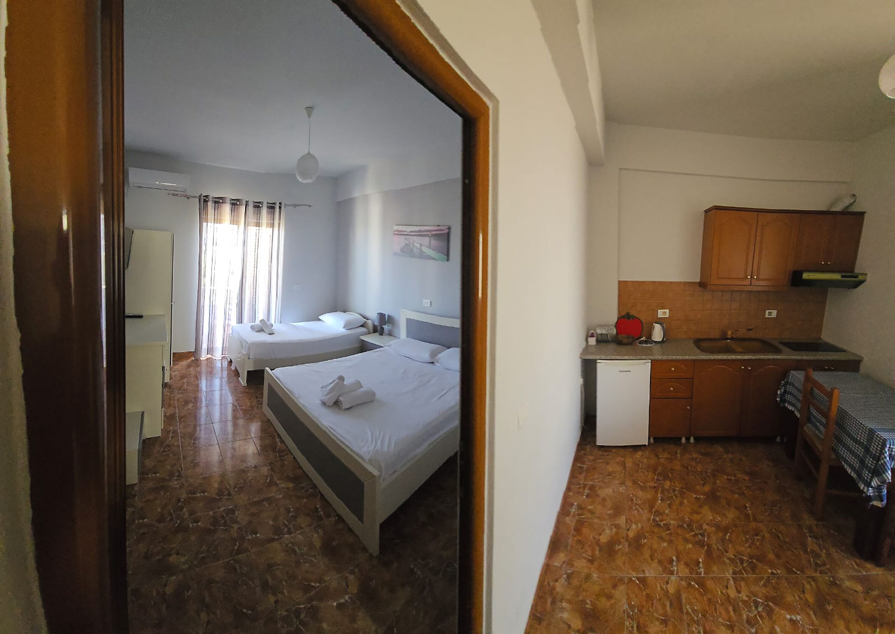Une chambre d’hôtel avec deux lits, une petite kitchenette et une salle de bain.