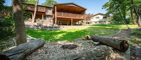 A two-story house with a wooden deck and a covered outdoor area.