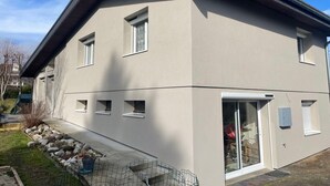 Een modern gebouw met twee verdiepingen, een plat dak, grote ramen en een zichtbare garage.