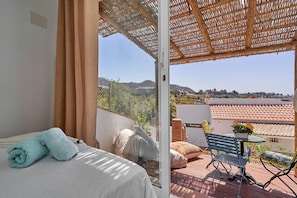 Enjoy a restful stay with a balcony offering a serene view of the surrounding hills and water.