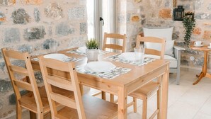 A wooden dining table set with plates, glasses, and a small plant.