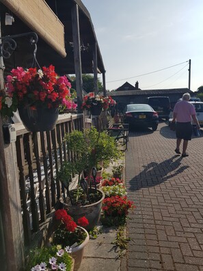Ett trästaket med krukväxter och blommor.