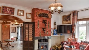 A cozy living room with a fireplace, a television, and a comfortable seating area. - Shiralee Holiday Home (Salisbury)