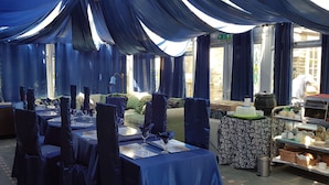 A banquet hall with tables set for a formal event, draped with blue fabric, and a coffee station in the background. - Shiralee Holiday Home (Salisbury)