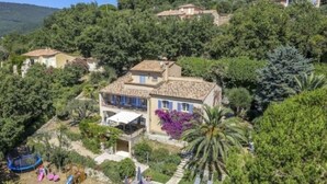 Una villa con piscina rodeada de exuberante vegetación y vistas a la colina.