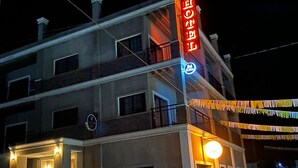 A hotel with a prominent red sign, multiple balconies, and a well-lit entrance. - Casa Camotlan (La Yesca)