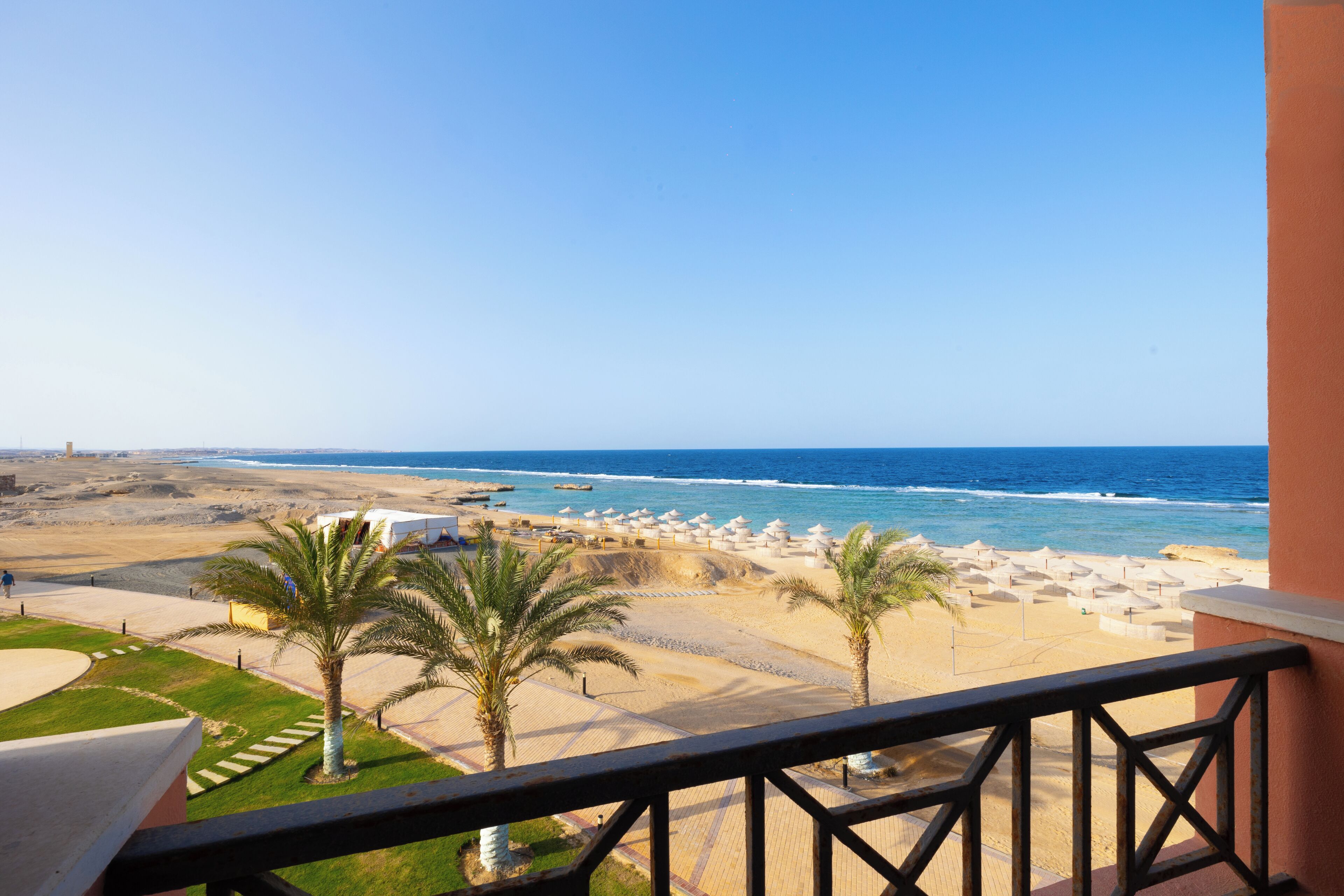 A balcony with a view of a beach and ocean.