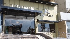 The entrance to Latent Suites with a modern design, featuring a glass facade and a metal staircase leading up to the entrance. - Laten Suites Prince sultan (Jeddah)