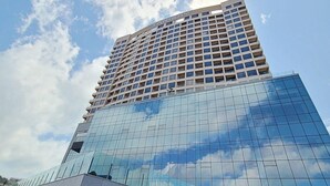 A high-rise building with a modern glass facade and a grid of windows. - Tanibay Hotel & Wedding (Ulsan)