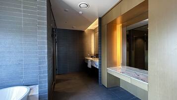 Un baño moderno con bañera, lavamanos y espejo.
