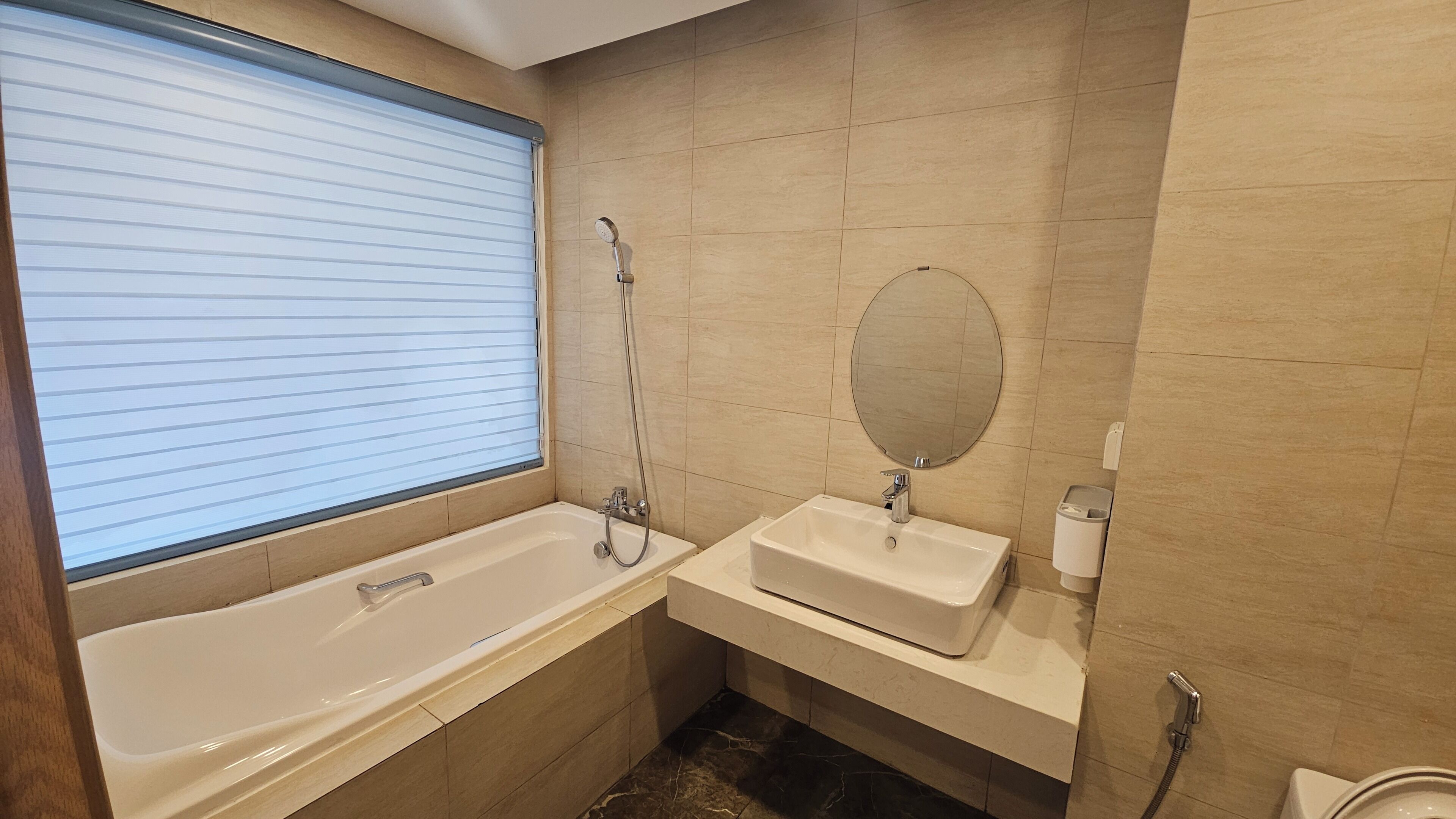 Une salle de bain avec une baignoire, un lavabo, un miroir et des toilettes.