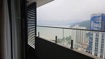 Uma varanda com vista para um rio e montanhas ao longe.