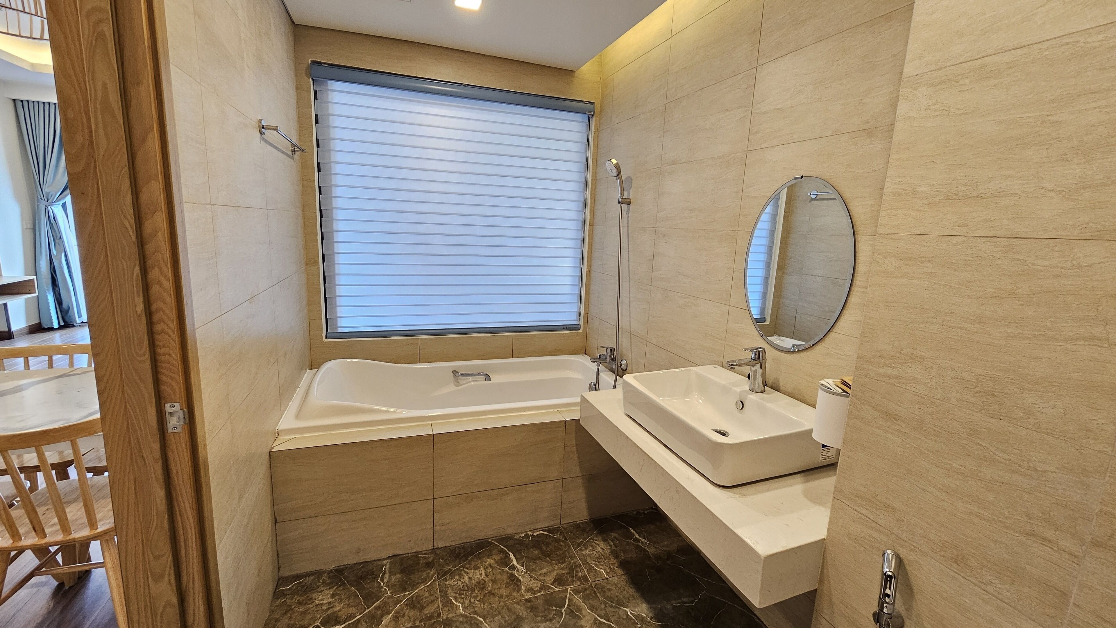 A modern bathroom with a bathtub, a sink, and a mirror.