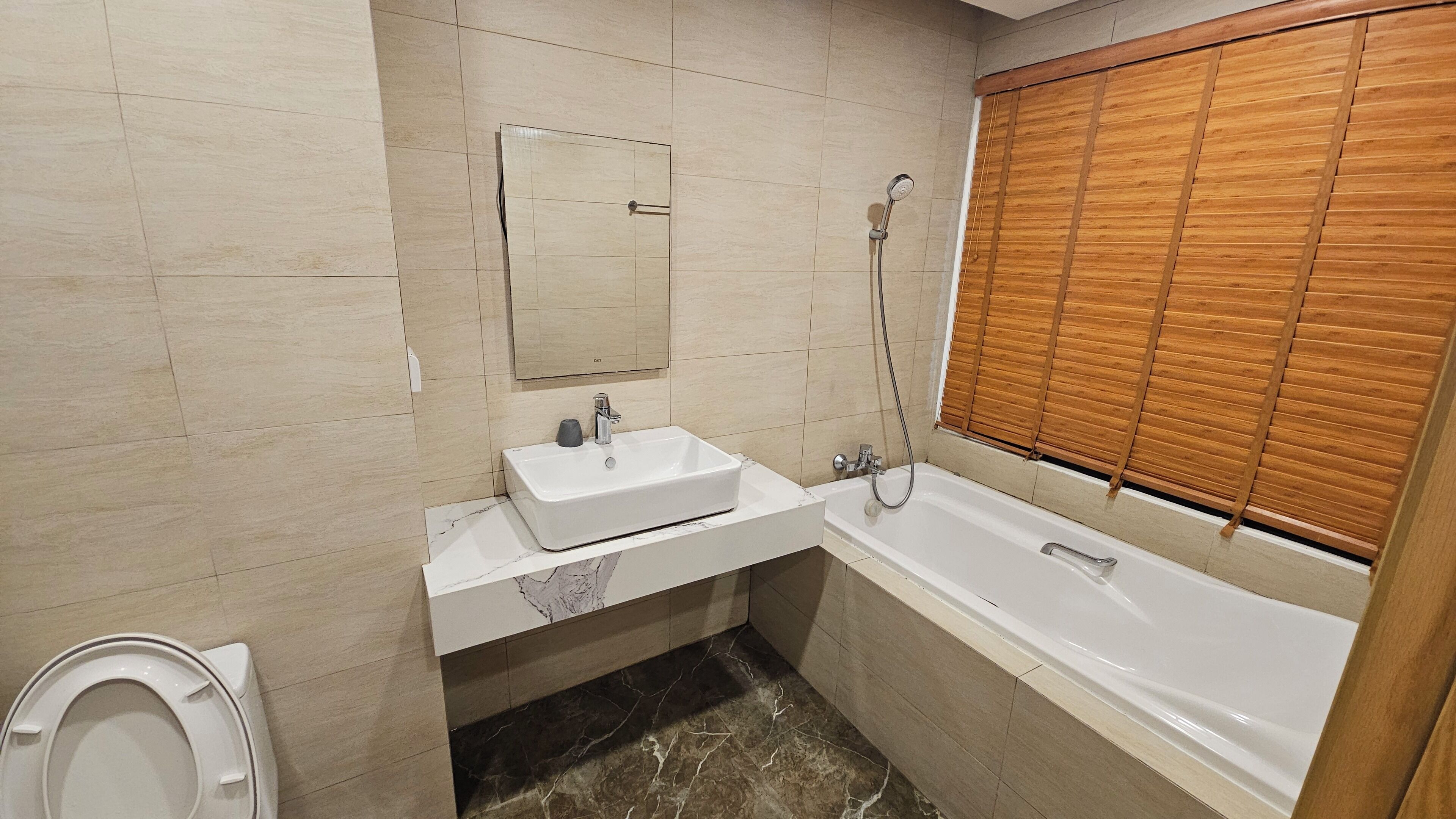 A bathroom with a white sink, a mirror, a shower, and a bathtub.