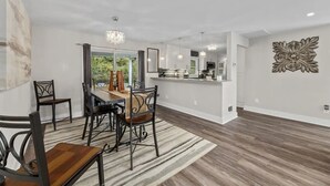A modern kitchen with white cabinets, a central island, and pendant lighting.