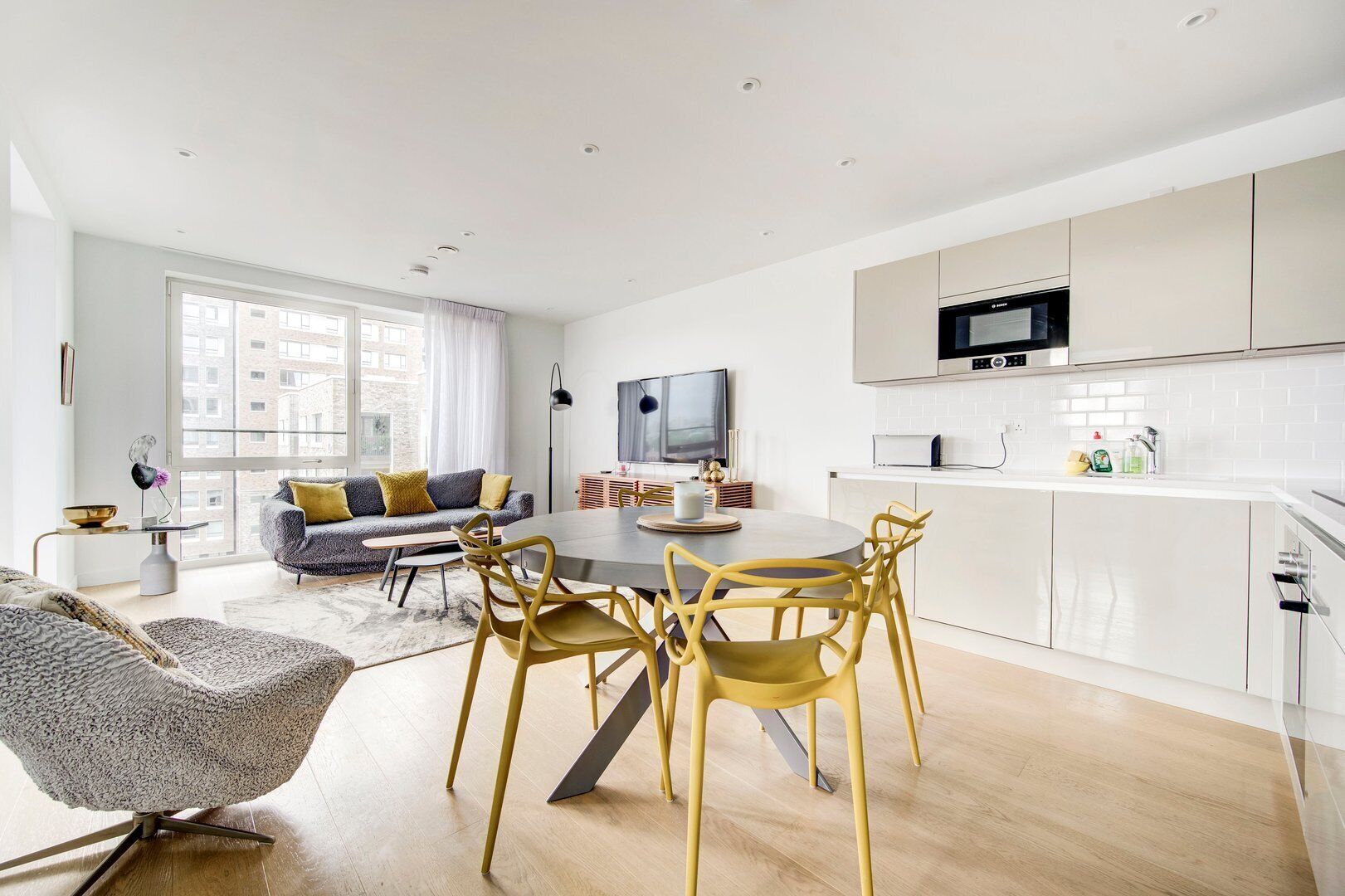 Un apartament modern amb zona de menjador, cuina i espai de sala d'estar.
