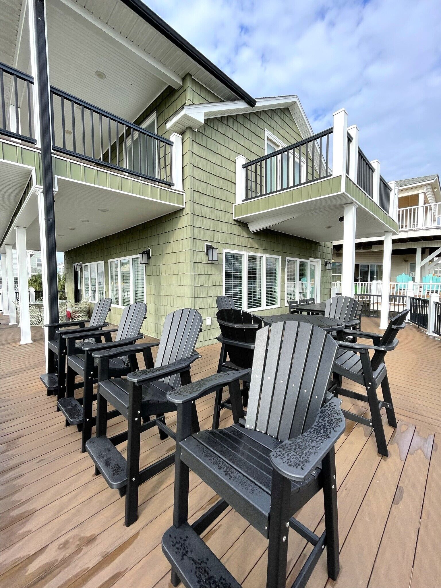 Eine Terrasse mit Adirondack-Stühlen und Holzboden.