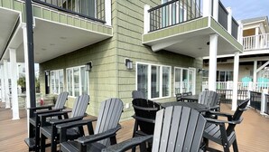 Une terrasse dotée de chaises Adirondack et d’un plancher en bois.