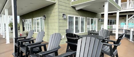En terrass med Adirondack-stolar och ett trägolv.