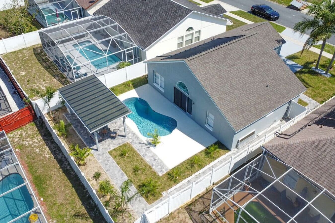A residential property with a swimming pool, a covered patio, and a garage.