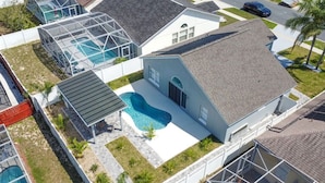 A residential property with a swimming pool, a covered patio, and a garage. - 8615 Vacation Oasis House Private Pool Grill (Kissimmee)