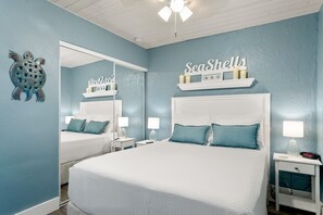Une chambre à coucher avec un grand lit, une table de chevet, un miroir et un élément décoratif mural.