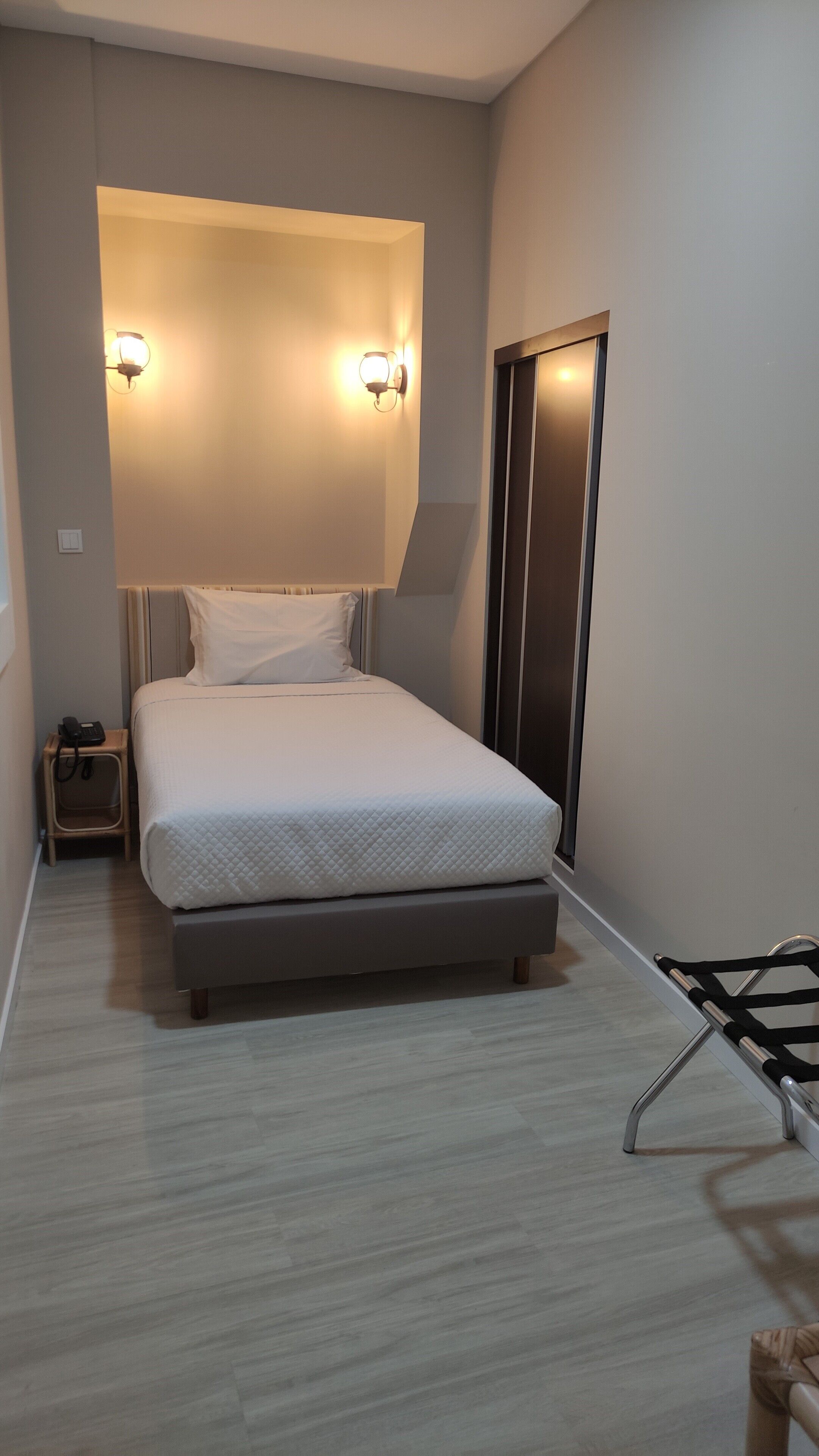 A modern bedroom with a bed, bedside tables, and a wardrobe.