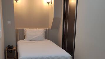 A modern bedroom with a bed, bedside tables, and a wardrobe.