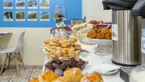 Uma mesa de buffet com diversos doces e uma máquina de café.