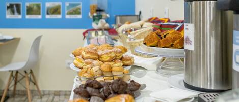 Una mesa de buffet con diversos pasteles y una máquina de café.