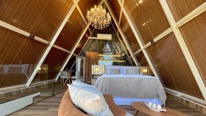 Um interior com cama, área de estar e um candelabro.